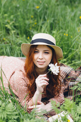 Red-haired girl walks in a spring blooming apple orchard