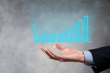 Businessman holding graph growth and increase of chart positive indicators in his business.Investment up concept.analyzing sales data and economic,strategy and planning, Digital marketing and stock 