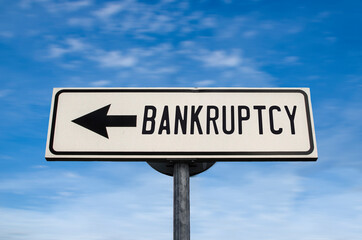 Bankruptcy road sign, arrow on blue sky background. One way blank road sign with copy space. Arrow on a pole pointing in one direction.
