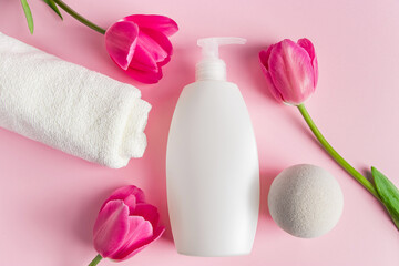 Spa skin care products on a pink background. Natural cosmetics and red tulips.