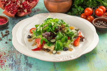 summer Lettuce salad with avocado and strawberry on the table