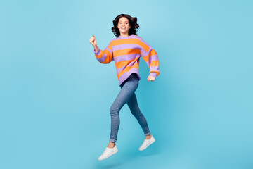 Fototapeta na wymiar Full length body size view of lovely glad motivated fit cheerful wavy-haired girl jumping running action isolated over bright blue color background