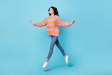 Fototapeta na wymiar Full length body size view of pretty dreamy carefree fit cheerful wavy-haired girl jumping going isolated over bright blue color background
