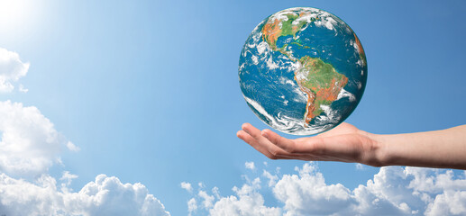 Hands holding a planet, earth on a background of nature blue sky with beautiful white clouds and sunlight.Sustain earth concept. Elements of this image furnished by NASA