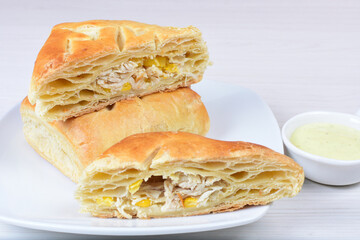 Puff pastry with vegetables and cheese displayed on white wooden background