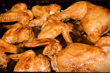 chicken legs and wings on a baking sheet baked in the oven