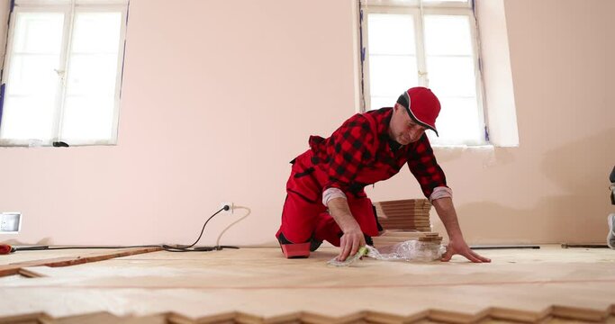 Man Installing Laminate Flooring. Laying parquet. Construction in a renovated room installation of parquet