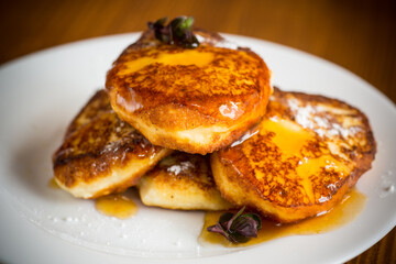 sweet fried cottage cheese pancakes with jam in a plate