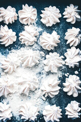 Meringue cookies on a blue background. Meringue background. Confectionery goodies