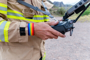 Fototapeta premium firefighter ,, with LGBT bracelet, operating drone in search and rescue