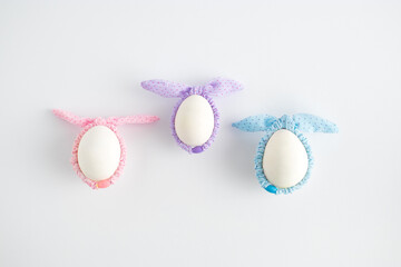 Creative composition with Easter egg and colorful hair bands on a white background. Minimal Easter or food concept. Flat lay.