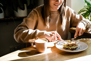 Young woman smiling and enjoying in taste avocado toast. Happy healthy breakfast concept