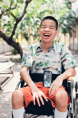 Asian special child on wheelchair using a smartphone on the ramp for disabled people background, Social of communication, Life in the education age of disabled children, Happy disability kid concept..