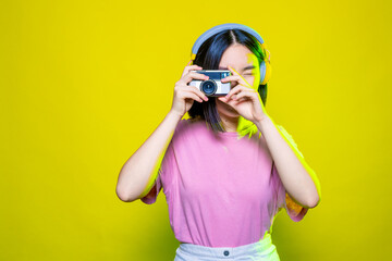 Studio shot young beautiful asian woman taking pictures with camera