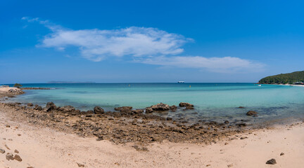 panorama landscape of wide sand and rock beach with blue sea and clear sky with clouds, relax calm seascape view at Thian beach, Koh Larn island, Chonburi, Thailand