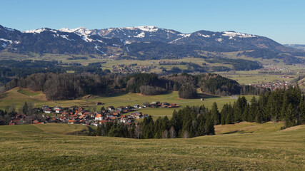 Winteruntypisches Bergpanorama in den Allg&auml;uer Alpen mit gr&uuml;nen Talflanken und Schnee nur auf den Gipfeln