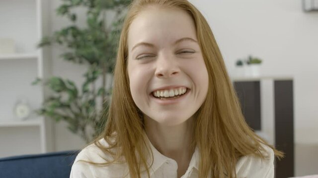 Cheerful blond teenage girl sincerely laughing at camera, good mood, happiness