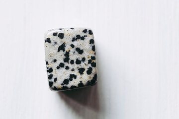 Pierre roulée polie jaspe dalmatien sur un fond blanc - Minéral naturel	