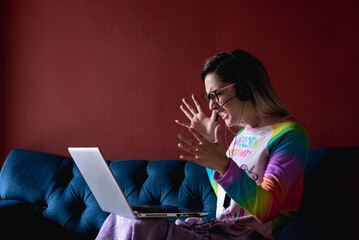 Joven enfadada con tecnología en el sofá y con pijama