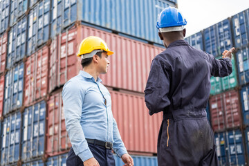 Selective focus at African black worker while talk and having discussion with supervisor and inspect the condition of all containers shipment, People and worker in freight deliver, import and export.