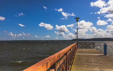 Promenade und Steg am Strand vom Zarnowitzer See in Polen an einem warmen Sommertag. Am Ufer einer...