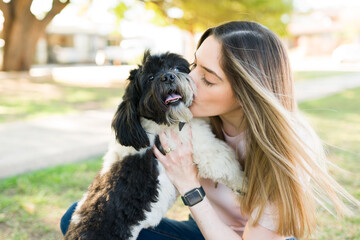 Loving woman giving kisses to her adorable pet