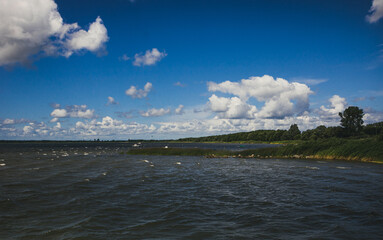 Harmonische Aufnahme am Wasser mit schönem Wolkenband im Sommer am Badesee in monochrom...