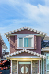 A perfect neighborhood. Houses in suburb at Summer in the north America. Fragment of a luxury house with nice window over blue sky.