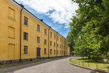 Yellow building . In front of him is a road and a beautiful park .