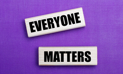 On a lilac bright background, light wooden blocks with the text EVERYONE MATTERS