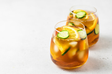 Summer drinks cucumber orange iced tea in glasses. Space for text.