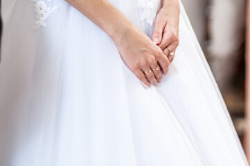 Obraz na płótnie Canvas Hands of the bride on a white dress