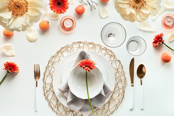 Effortless Summer birthday dinner table setup, set. White dinner table, white and gold utensils, decorated with peony flowers, vibrant orange gerberas, pale yellow peony flowers and tasty orange