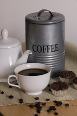 Coffee cup with cupcake on table