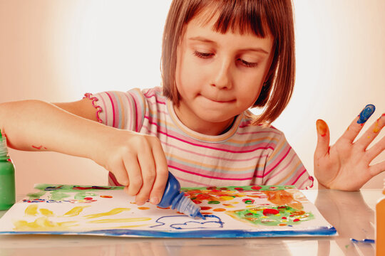 Process of painting. Close up beautiful child girl painting picture. Horizontal image.