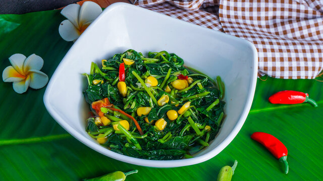 Selective focus of sayur bayam bening or spinach clear soup with corn in white bowl , Indonesia Traditional Soup