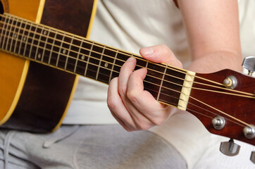 Fototapeta na wymiar male fingers playing acoustics arm guitar strings