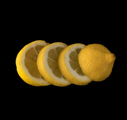 Lemon sliced in round slices on black background isolated
