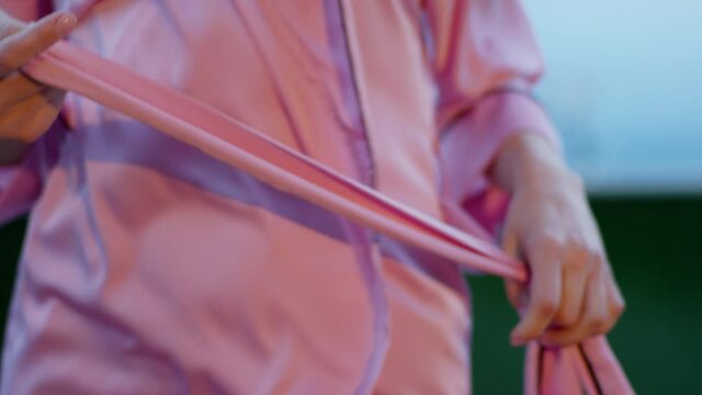 Closeup to the camera lady on the roof top of loft apartment take off her pink robe outside it s a windy day
