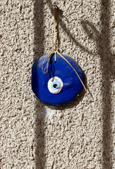 blue evil eye bead on the old stone wall