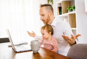 sad and frustrated father in kitchen home office with computer and her daugher
