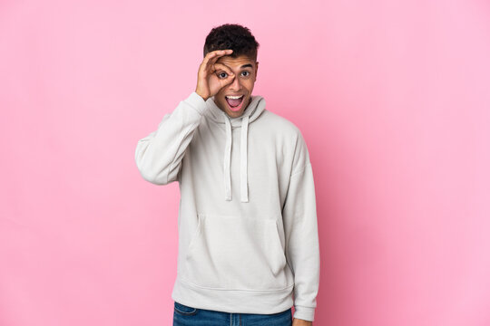 Young Brazilian man isolated on pink background showing ok sign with fingers