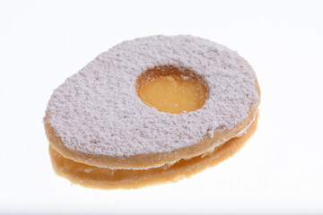 Egg shaped biscuit with sweet yellow filling and sugar powder on top.Isolated on white
