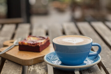 Caffe latte art on wooden table with brownie 