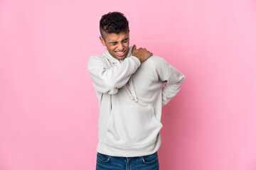 Young Brazilian man isolated on pink background suffering from pain in shoulder for having made an effort