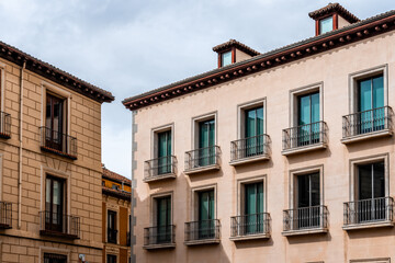 Fototapeta na wymiar Old Traditional Residential Buildings in Central Madrid. Colorful Facades Against Cloudy Sky