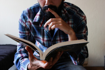 Hombre joven con barba leyendo