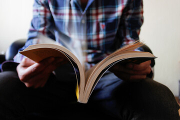 Hombre joven leyendo pasando páginas