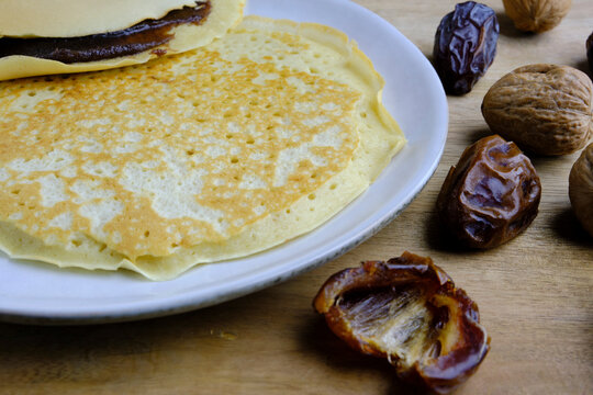 Food background with Moroccan Jewish pancakes Molfetta for Mimouna celebration, date fruit spread on wooden surface. 