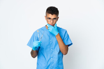 Brazilian dentist holding tool isolated on white background thinking